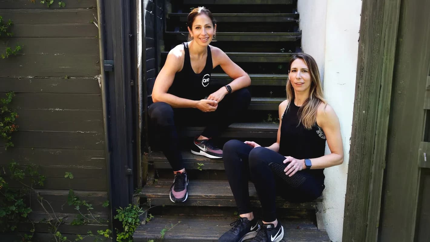 Anna and Charlotte, founders of ace lifestyle, sitting together on the studio steps in NW London